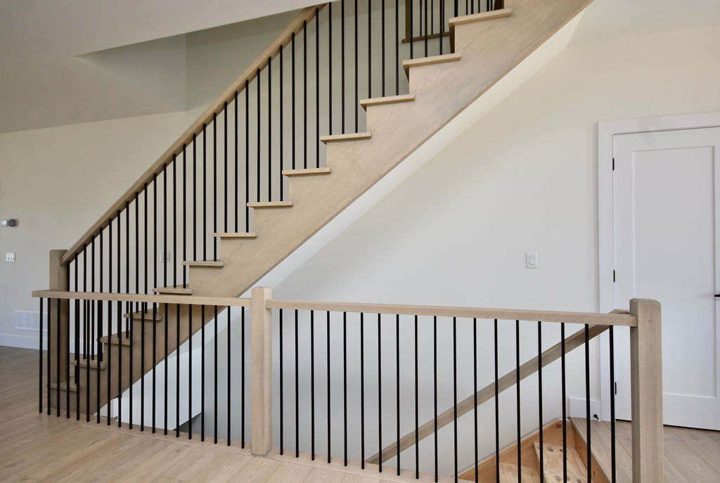 The staircase to the second floor and down to the basement with iron spindles.