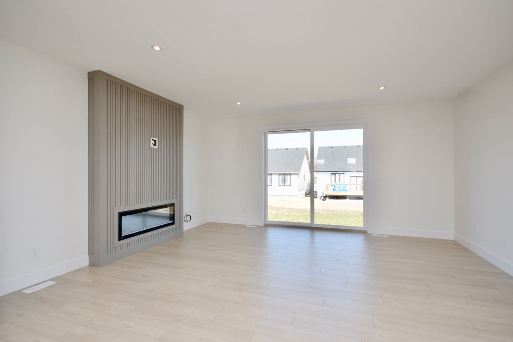 Large living room area with sliding door to the backyard and gas fireplace feature.