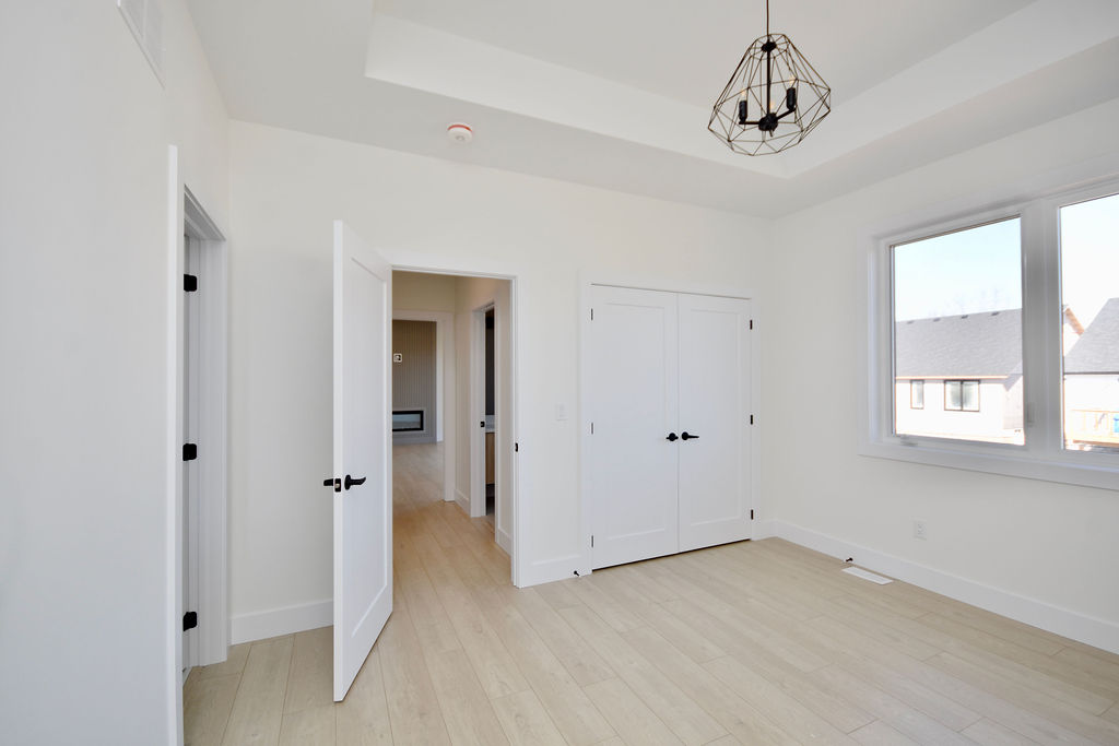 Inside main floor primary bedroom with double door closet and ensuite bathroom.