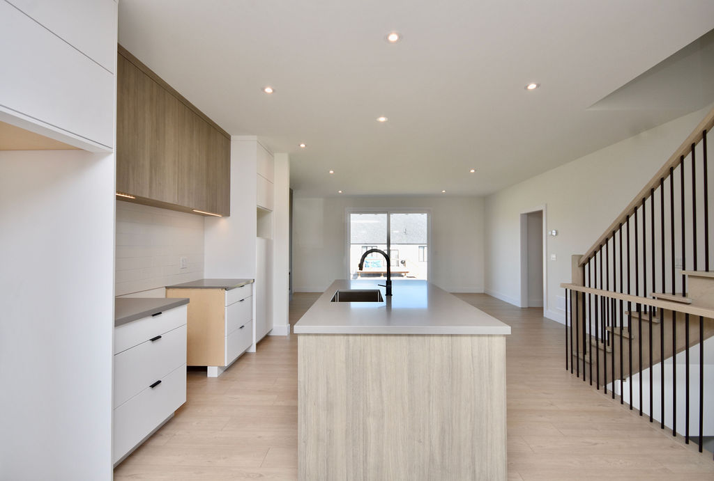 View looking down the large kitchen island toward the back of the home.